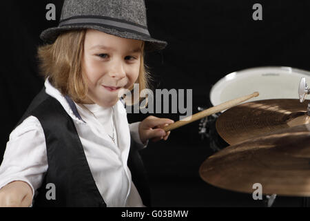 kleiner Junge ist ambitioniert Schlagzeug spielen. Stockfoto