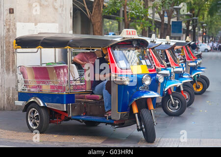 Linie der Tuktuks mit Fahrer in Bangkok Straße Stockfoto