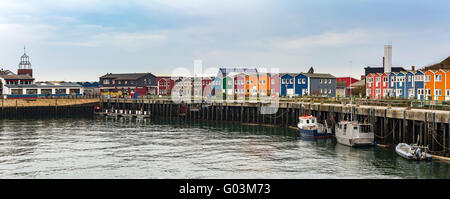 Panorama von farbigen Krabbe Fisher Ställe am Hafen Insel Helgoland, Deutschland, Häuser nordischen Stil mit Boot und blauer Himmel Stockfoto