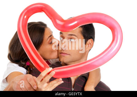 Junge Paar küssen durch Ballon Herz Überraschung isoliert auf weißem Hintergrund Stockfoto