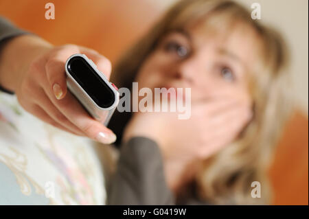 Die Frau mit einem TV-Bedienfeld. Selektiven Fokus Stockfoto