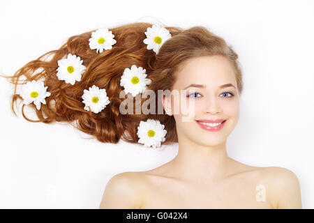 Schöne Mädchen mit Blumen im Haar auf einem hellen Hintergrund Stockfoto