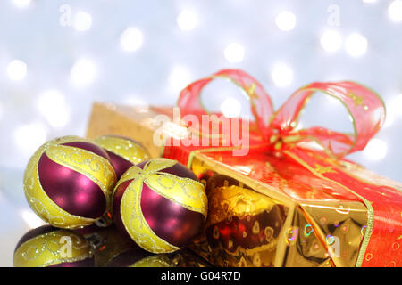 Weihnachtskugeln und Geschenk-Box auf der Hintergrund-Beleuchtung Stockfoto