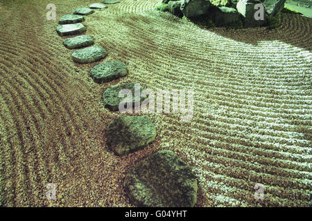 steinernen Pfad zwischen Sand Wellen im Zen-Garten Stockfoto