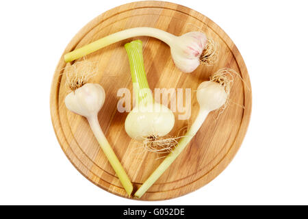 Knoblauch und Zwiebeln Köpfe auf ein Schneidebrett. Weißem Hintergrund Stockfoto