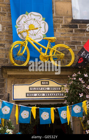 Großbritannien, England, Yorkshire, Haworth 40er Jahre Wochenende, Main Street, gelbe Tour de Yorkshire Fahrrad über Eingang Haus B & B zu schlafen Stockfoto