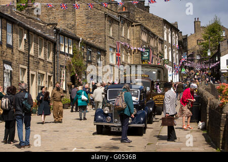 Großbritannien, England, Yorkshire, Haworth 40er Jahre Wochenende, Besucher und Fahrzeuge in der Main Street Stockfoto