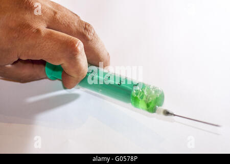 Die Hand eines Mannes mit einer Spritze Stockfoto