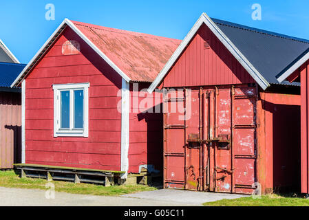 Falsterbo, Schweden - 11. April 2016: Zwei Fischerhütten oder Werkzeug Schuppen im Hafen. Man ist eine getaktete Frachtcontainer mit r Stockfoto