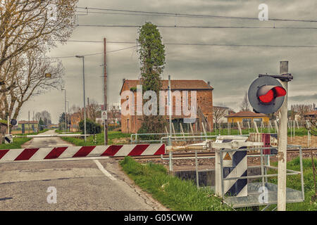 für die Durchfahrt des Zuges an einem Land-Bahnübergang warten Stockfoto