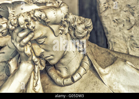 bestäubt Statue der weinenden Engel hält seinen Kopf während Tränen fließt auf Nase Stockfoto