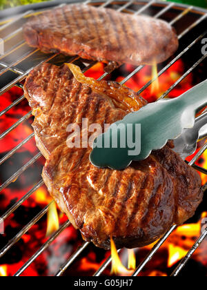 Grill-Steak auf dem Bbq Grill Flamme kochen Stockfoto