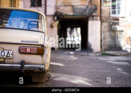 Odessa, Ukraine - 16. April 2016. Alten Beiege Autos Rücklicht und eine verschwommene Person auf der Straße. Stockfoto