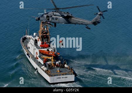 US Air Force HH - 60G Pave Hawk Hubschrauber führt ein Hebezeug eines Matrosen von der US Coast Guard Cutter Long Island während Rettung Ausbildung 14. März 2012 in der Nähe von Valdez, Alaska. Stockfoto