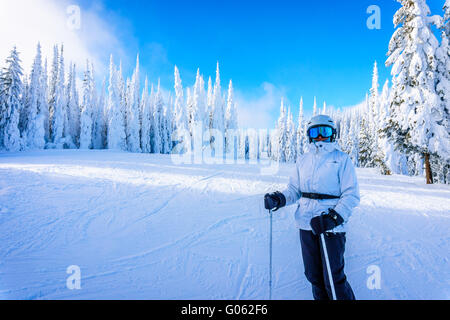 Frau genießen den Blick auf die Skipisten von Sun Peaks Skigebiet umgeben von tief verschneiten Bäumen in den hohen Alpen Stockfoto