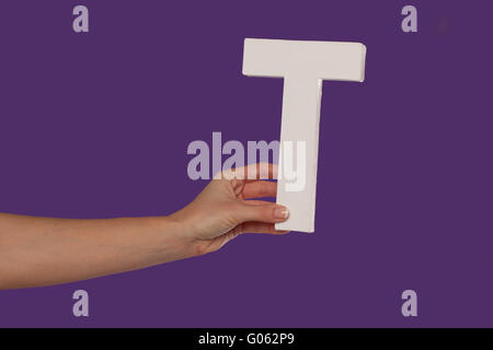 Weibliche Hand, die den Brief T v.l. Stockfoto