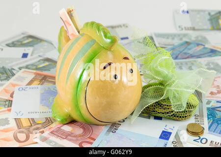 Spielzeug-Fisch-Sparschwein auf Euro-Scheine Stockfoto