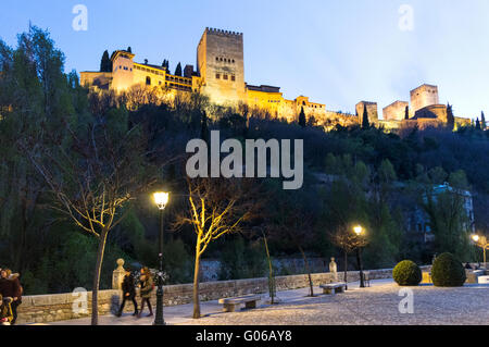Alhambra-Palast beleuchtet, wie gesehen von Paseo de Los Tristes Straße im Viertel Albayzin, Granada, Andalusien, Spanien Stockfoto