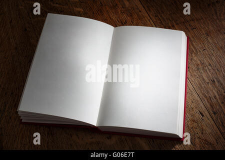 Offenes Buch schräg mit leeren weißen Seiten auf Eiche Hintergrund Stockfoto