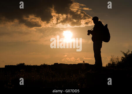Fotograf-Silhouette bei Sonnenuntergang im Gebirge Stockfoto