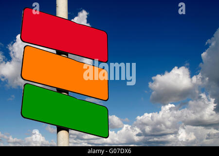 Rote, gelbe und grüne Zeichen vor einem blauen bewölkten Himmel leer Stockfoto