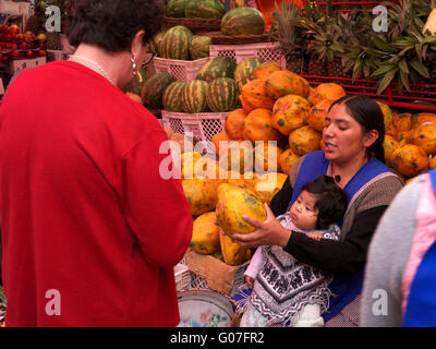 Frauen im Markt mit Kind auf ihrem Schoß verkaufen Obst und Gemüse Stockfoto
