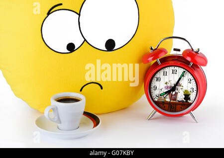 Große gelbe Lächeln, eine Tasse Kaffee und ein Alarm-clo Stockfoto