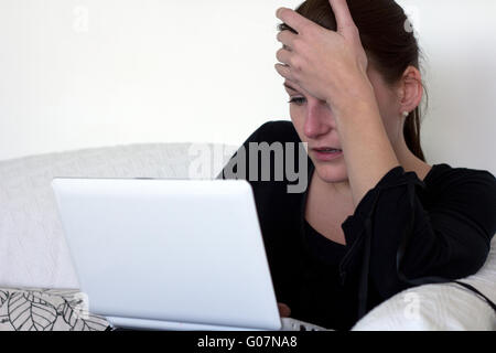 Frustriert weiße Frau auf ihrem Laptop arbeiten und hielt ihren Kopf mit der Hand Stockfoto