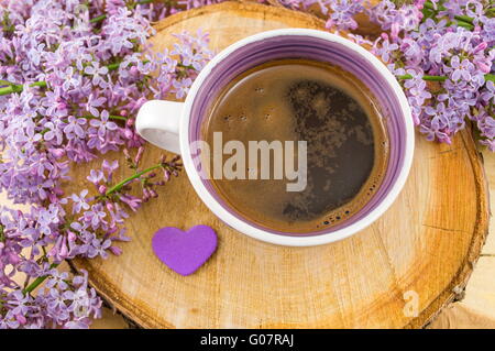 Tasse Kaffee und lila Blumen Stockfoto
