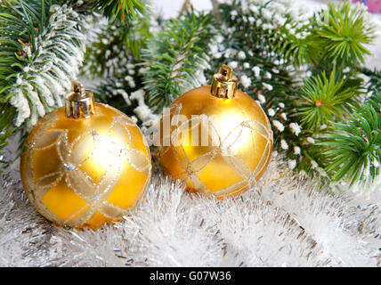 Zwei gelbe Neujahrs Kugeln und verschneite Branč Stockfoto