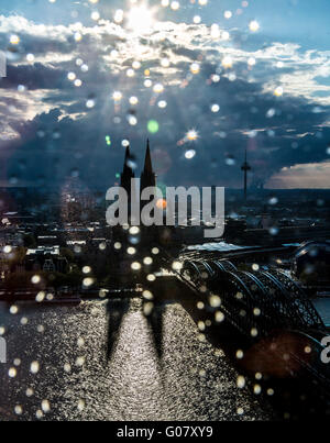 Kölner Dom, Rhein, Eisenbahnbrücke Hohenzollern, Skyline, Sonnenuntergang, alte Stadt, Stadtansicht, Regentropfen auf ein Fensterglas Stockfoto