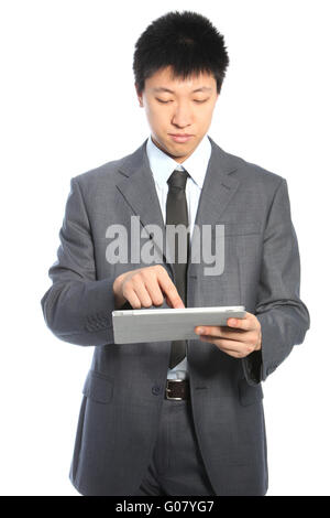 Junge asiatische Geschäftsmann auf einem Tablet PC arbeiten Stockfoto