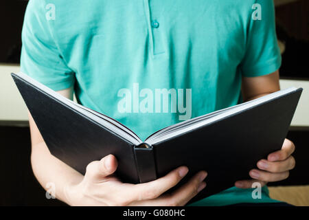 Junger Mann liest ein Buch sitzend auf Bett - Bildung und Literatur Konzept Stockfoto