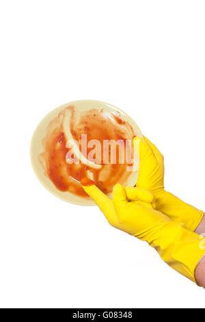 Hand im gelben Gummihandschuh auf schmutzigen plat Stockfoto