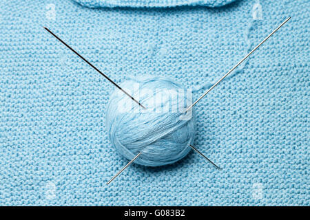 ball of blue wool with steel knitting needles Stockfoto