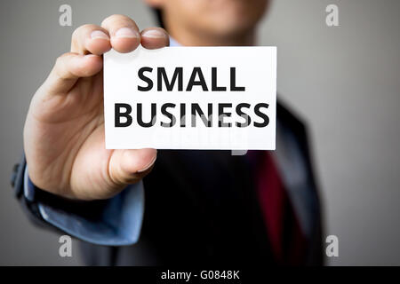 Geschäftsmann präsentiert "Small Business" Wort auf weißem Karton. Stockfoto