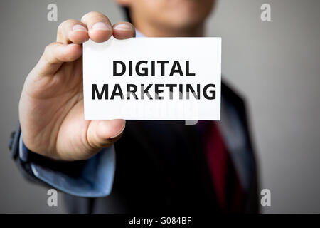 Geschäftsmann präsentiert "Digital Marketing" Wort auf weißem Karton. Stockfoto