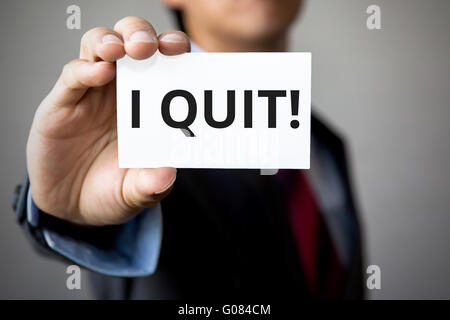 Geschäftsmann präsentiert "I Quit" Wort auf weißem Karton. Stockfoto