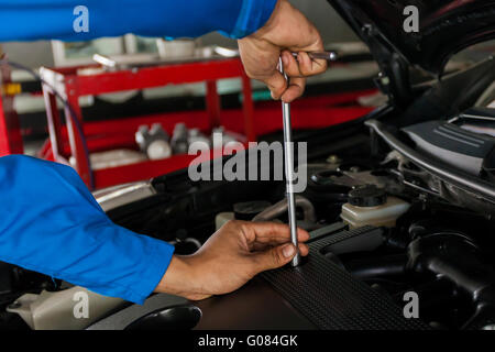 Mechanische Prüfung und Festsetzung ein kaputtes Auto in Auto-Werkstatt mit textfreiraum (Schwerpunkt Schraubendreher) Stockfoto