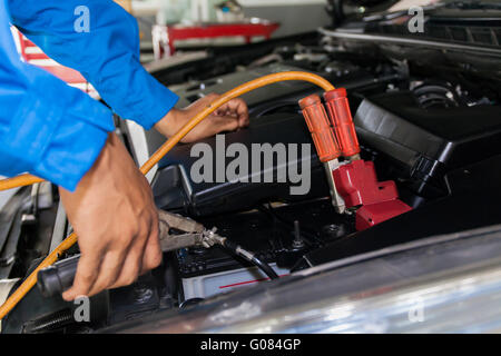 Mechaniker anbringen Starthilfekabel mit Batterie Auto - Nahaufnahme Stockfoto