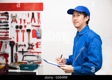 Junge männliche Ingenieur bei der Arbeit in mechanische Werkzeuge Lagerraum. Stockfoto