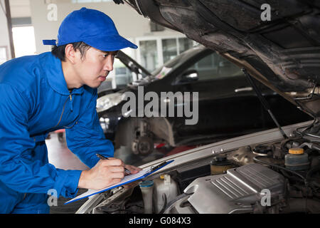 Mann im blauen Techniker einheitliche gehen für Wartung des Autos zu reparieren. Stockfoto
