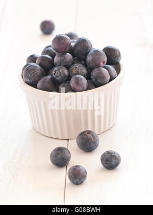 Frische Heidelbeeren in einer Schüssel auf einem weißen Holz Tablett Stockfoto