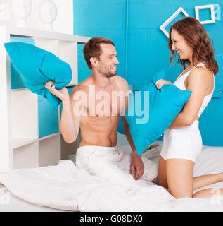 Junge Paare, die Spaß machen Kissen Kampf. Stockfoto