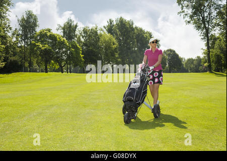 Golfer mit Wagen auf dem Platz vor anzeigen Stockfoto