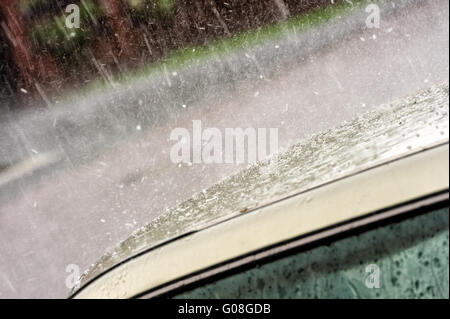 Autodach in Starkregen und Hagel Stockfoto