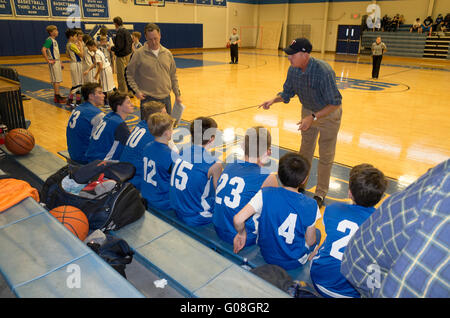 Basketball-Trainer mit Begeisterung unterrichten seine junge Teen Spieler auf der Bank ausruhen. Mendota Heights Minnesota MN USA Stockfoto