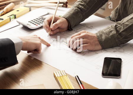 Geschäftsmann und Bau-Ingenieur zusammen zu arbeiten, der Kunde weist auf das Projekt auf dem Schreibtisch Stockfoto