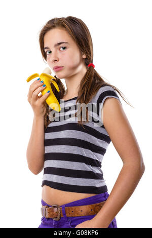 Teenager-Mädchen essen eine Banane, isoliert auf weiss Stockfoto