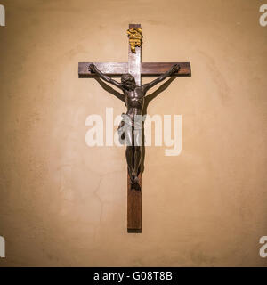 Kruzifix an der Wand im Rampenlicht. Jesus Christus am Kreuz. Religion, glaube und Hoffnung. Heilige und heilige Orte. Stockfoto